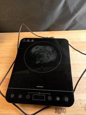 a black stove top with a black burner on top of it