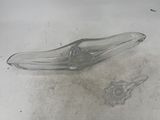 a broken glass spoon sitting on the floor next to a toothbrush