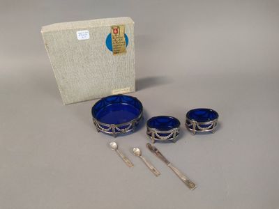 a silver and blue bowl, spoon, and spoon rest on a table