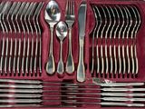 silverware in a red case on a table with spoons, forks, and spoons