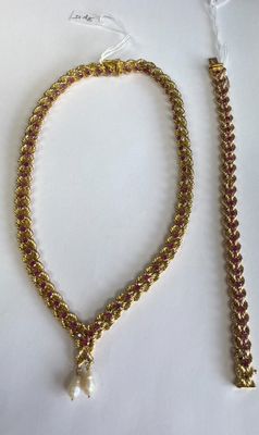 un gros plan d'un collier et d'un bracelet posés sur une surface blanche
