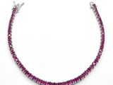 a close up of a necklace with a pink stone on it