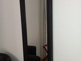 a large mirror hanging on the wall next to a black chair