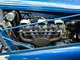 a close up of a blue car with a engine in it ' s trunk