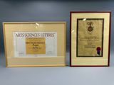 two framed pictures of a certificate and a certificate on a table