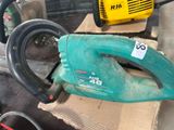 a green and black corded blower sitting on top of a cardboard box