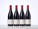 three bottles of red wine sitting on top of a table