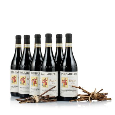 quatre bouteilles de vin rouge posées à côté d'un tas de brindilles