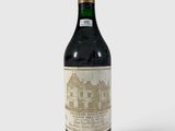une vieille bouteille de vin posée sur une surface blanche