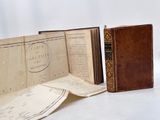 two old books sitting on a table next to each other