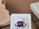 une bague sertie d'une pierre violette, posée sur une table