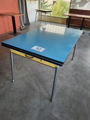 une table au plateau bleu dans une pièce aux murs orange