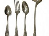 four spoons and a fork on a white surface