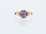 Gros plan sur une bague en or ornée d'un saphir bleu