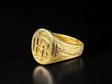 an image of a gold signet ring with the initials of a man and woman