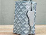 a small grey and white bag sitting on top of a wooden table