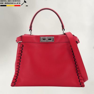 a red leather handbag with a metal handle