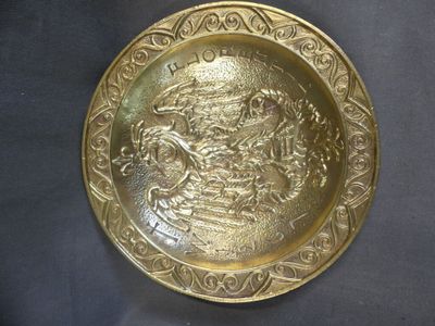 une assiette en or sur laquelle est représenté un homme