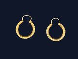 une paire de boucles d'oreilles en or sur fond noir