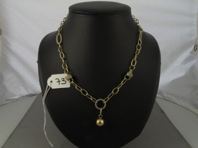 collier avec une boule et une chaîne en or, présenté sur un mannequin