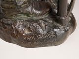 bronze statue of a man with a sword and a dog on a rock