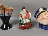 trois figurines en céramique posées les unes à côté des autres sur une table