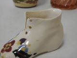 a close up of a shoe shaped vase on a table