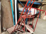 un diable rouge posé devant une pile de cartons