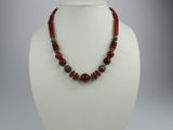 necklace with red and black beads on a white mannequin