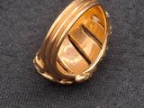 a close up of a gold ring on a black cloth
