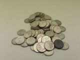 une pile de pièces d'argent posée sur un comptoir blanc