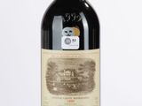 une vieille bouteille de vin rouge posée sur une table blanche
