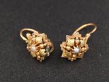 une photo d'une paire de boucles d'oreilles en or ornées de perles