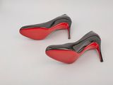pair of black and red high heeled shoes on a white surface