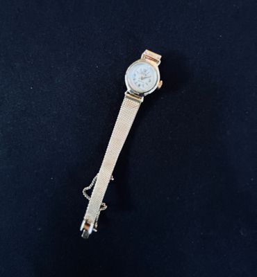 a close up of a watch sitting on top of a black surface