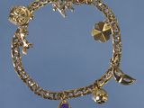 bracelet plaqué or orné de breloques, sur fond bleu