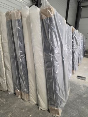 de nombreux matelas emballés dans du plastique dans un entrepôt