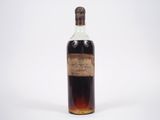 une vieille bouteille d'alcool posée sur une surface blanche