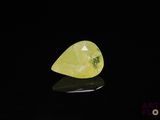 une pierre de quartz jaune posée sur une surface noire