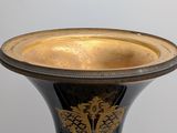 a black and gold vase sitting on a table