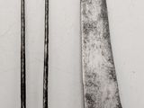 two knives and a fork on a table with a white background