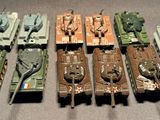 a lot of toy tanks that are lined up on a table
