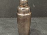 a small metal shaker sitting on a table
