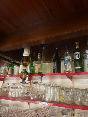 des bouteilles et des verres sont alignés sur une étagère dans un bar