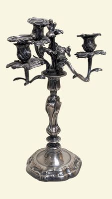 un candélabre en argent orné de trois oiseaux