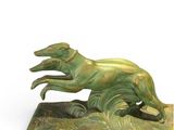 bronze sculpture of a running greyhound on a green base