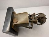 a bronze statue of a horse with a coin in its mouth