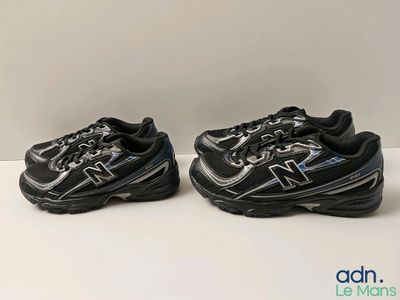 a pair of new balance shoes on a white surface