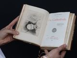 une personne tenant un livre ouvert sur lequel figure un dessin