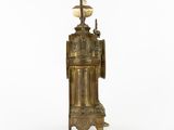 an antique brass clock with a marble top on a stand